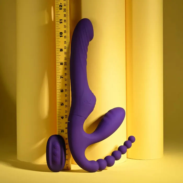 Purple silicone butt plug with spherical ends on a yellow background