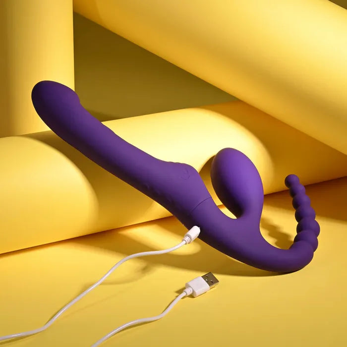 Purple silicone wand with USB cable on a yellow background