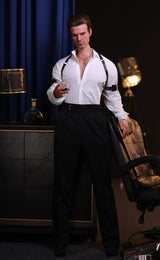 Mannequin wearing a white shirt and black pants in a room with a blue curtain and lamp.