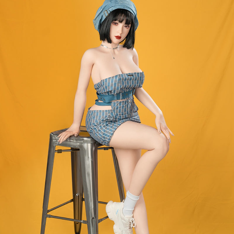 sex doll in a blue outfit sitting on a stool against an orange background